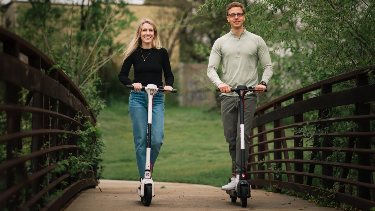 jeune couple se promenant en trottinette electrique Gotrax dans un parc